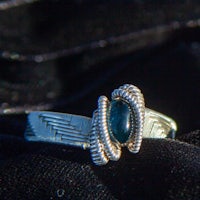 a silver ring with a blue stone on it