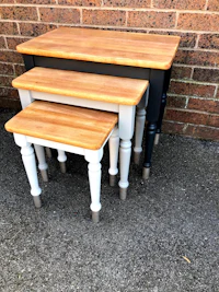 three nesting tables on a brick wall