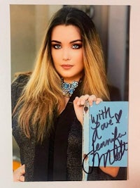 an autographed photo of a woman holding a book