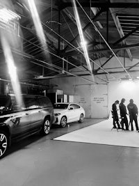 a black and white photo of a group of people in a garage