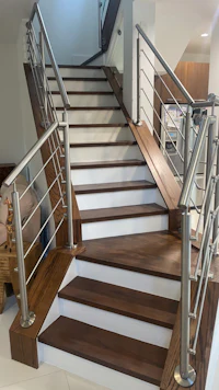 a staircase with metal railings and wood flooring