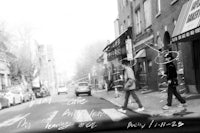 a black and white photo of two people walking down a street