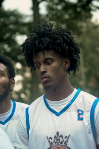 two young men in basketball uniforms standing next to each other