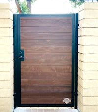 a wooden gate with a black metal frame