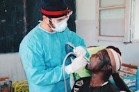 a man is giving a patient a dental exam