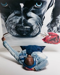 a man laying on the floor with a painting of a dog