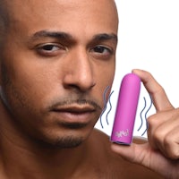 a man is holding a pink vibrator in his hand