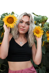 a blonde woman posing in a field of sunflowers