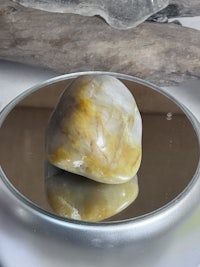 a mirror with a yellow stone in it