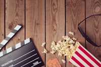 popcorn, glasses and movie claps on a wooden table stock photography