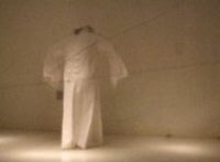a white mannequin standing in a dark room