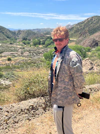 a man in a military uniform standing on a dirt road