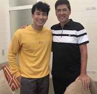 two men posing for a photo in a living room