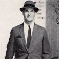 an old photo of a man in a suit and hat