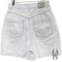 a pair of white denim shorts hanging on a hanger