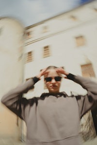a blurry image of a person with sunglasses in front of a building
