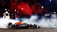 a red bull racing car with smoke coming out of it