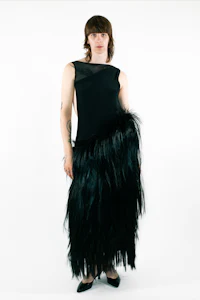 a woman wearing a black dress with feathers