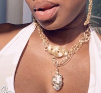 a woman wearing a necklace and earrings