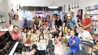 a group of people posing for a photo in front of a piano