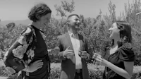 three people talking in a black and white photo