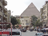 a street with buildings and a pyramid in the background