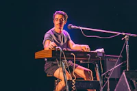 a man sitting on a keyboard in front of a microphone