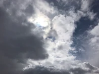 the sun shines through a cloudy sky