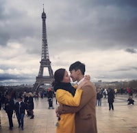 a couple embracing in front of the eiffel tower