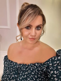 a woman in a green off the shoulder top posing for a photo