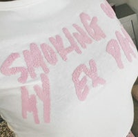 a woman wearing a t - shirt that says smoking on my ex