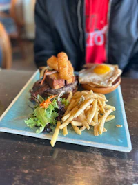 a plate of french fries and a burger with an egg on it