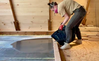 a woman working on a wooden floor in a room