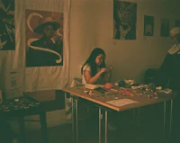 a group of people sitting at a table making crafts