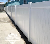 a white vinyl fence in front of a house