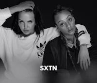 two women posing for a photo with the words sxtn