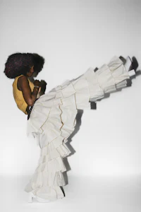 a woman in a white skirt doing a kick