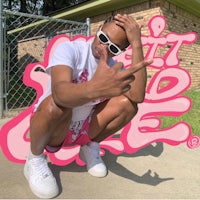 a man posing in front of a pink sign