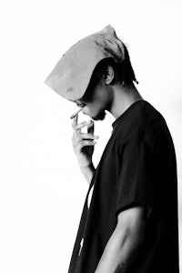 a black and white photo of a man smoking a cigarette