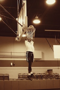 a man dunks a basketball in a gym