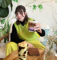 a man sitting on a chair holding a cup of coffee