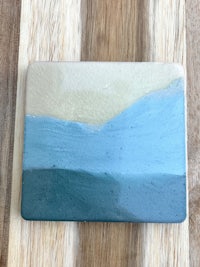 a ceramic coaster with a blue and tan design