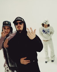 a group of people posing in front of a white background