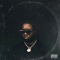 a man in sunglasses is standing in front of a circle