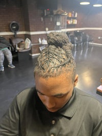 a man with a braided hairstyle in a salon