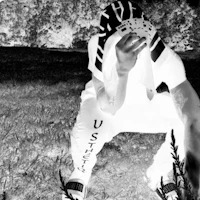 a black and white photo of a person crouching in the grass