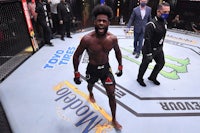 a ufc fighter is standing on the ring in front of a crowd