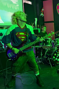 a man is playing a guitar in front of a screen