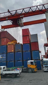 a truck is parked next to a container crane