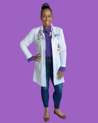 a woman in a lab coat posing for a photo